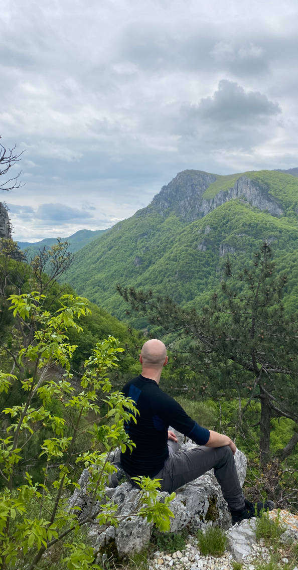 Kamil above a green valley